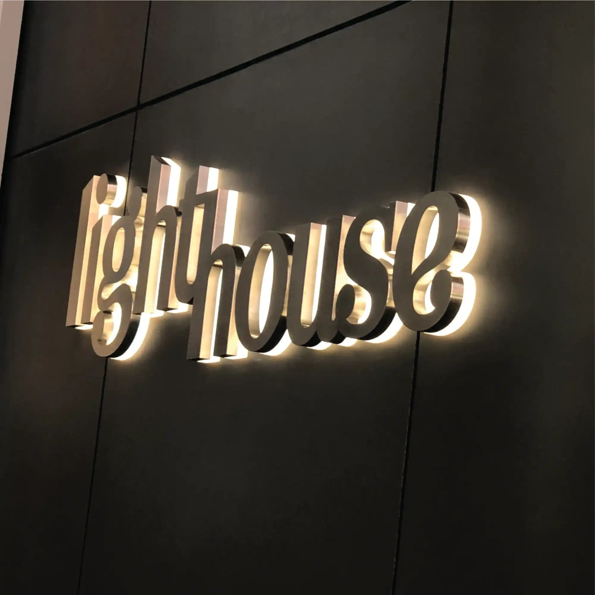 Backlit ’Lighthouse’ sign with reflective silver lettering.