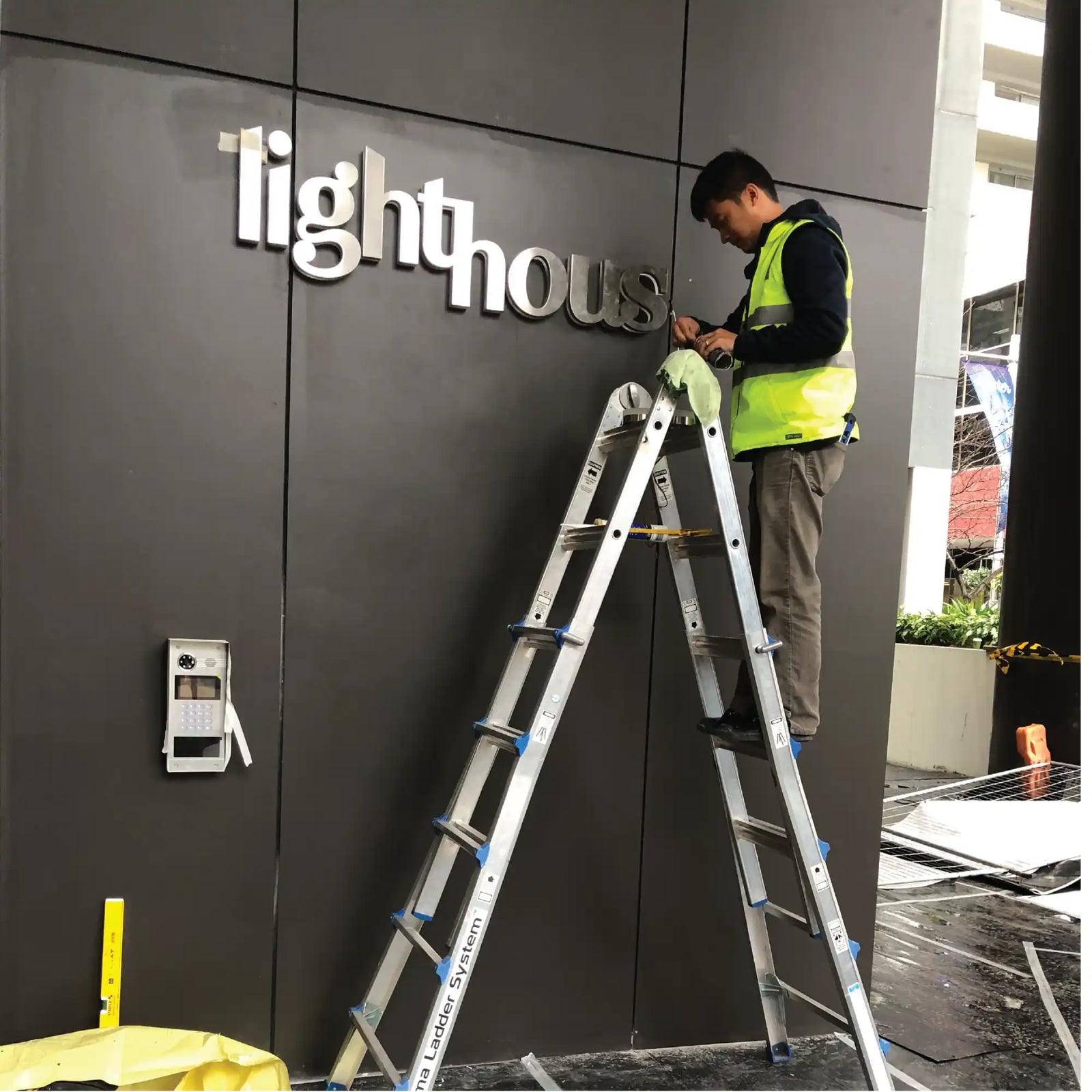 Installer working on illuminated building signage